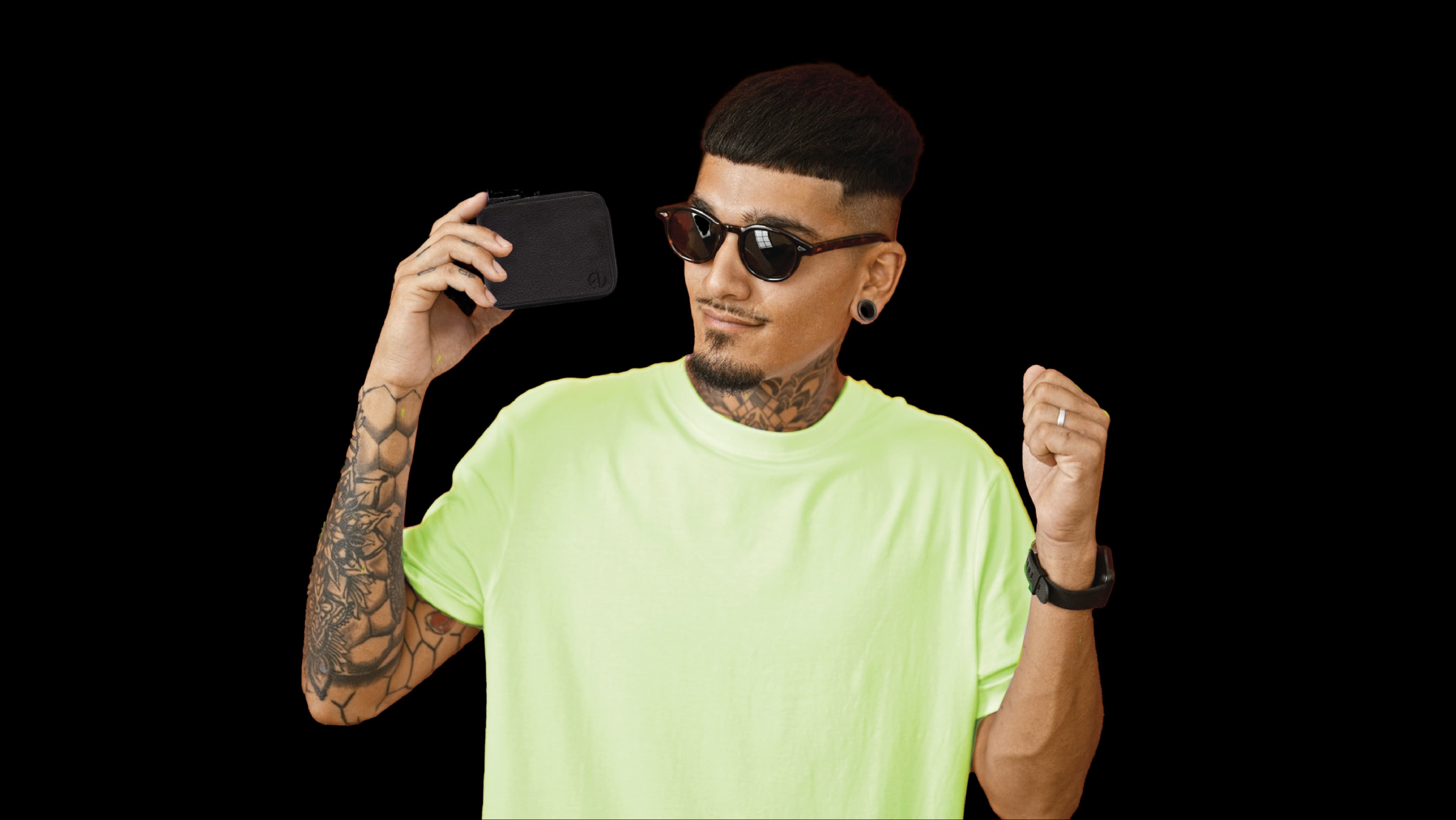 A man in a lime-green tee holding the Fresh'n Up wallet-shaped grooming kit
